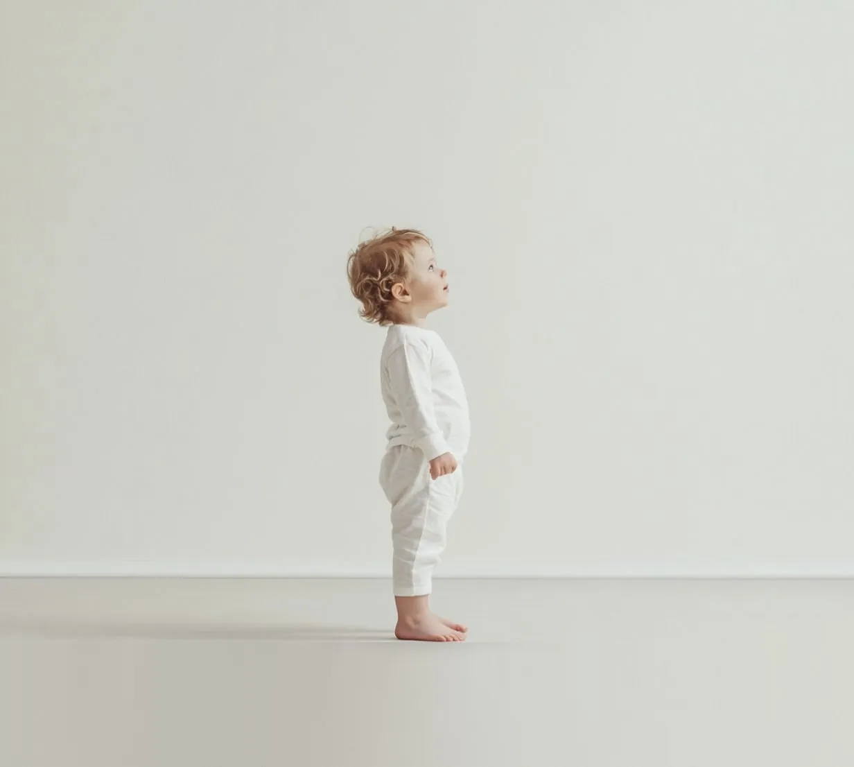 Un tout-petit debout, le regard levé vers l'avant